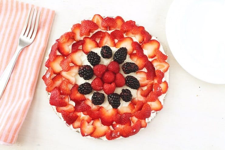 An overhead view of a cake covered in fresh berries.