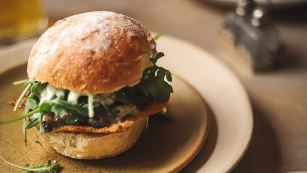 A single wagyu beef burger on a plate.