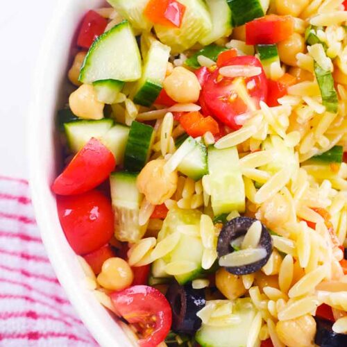 And up close view of a white bowl filled with Chickpea Orzo Salad.