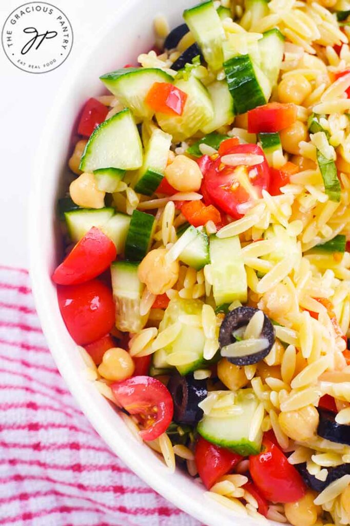 And up close view of a white bowl filled with Chickpea Orzo Salad.