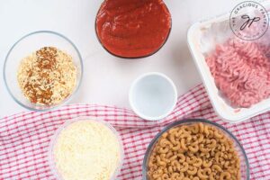 Chili Mac Recipe ingredients in individual bowls gathered on a white surface.