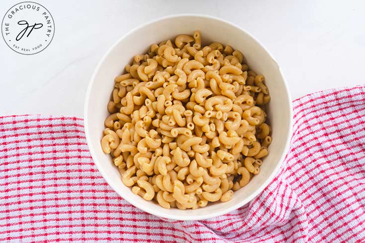 A white bowl filled with cooked macaroni noodles.