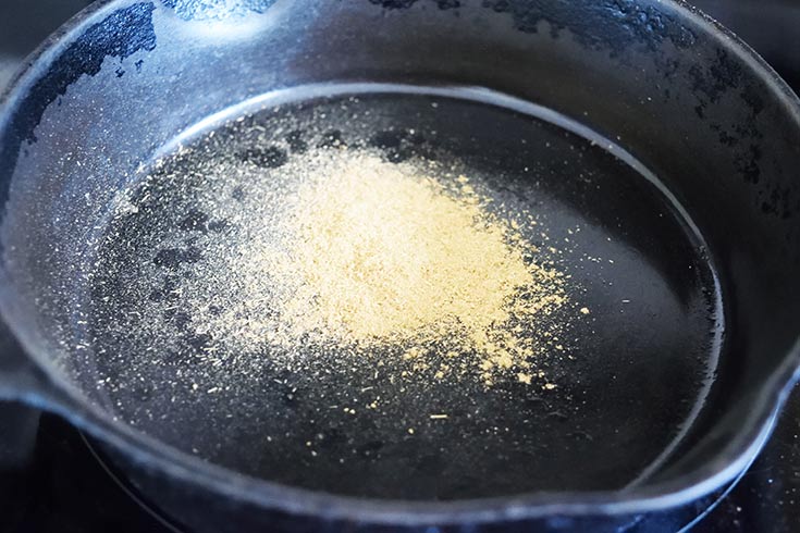 Dry spice roasting in a black skillet.