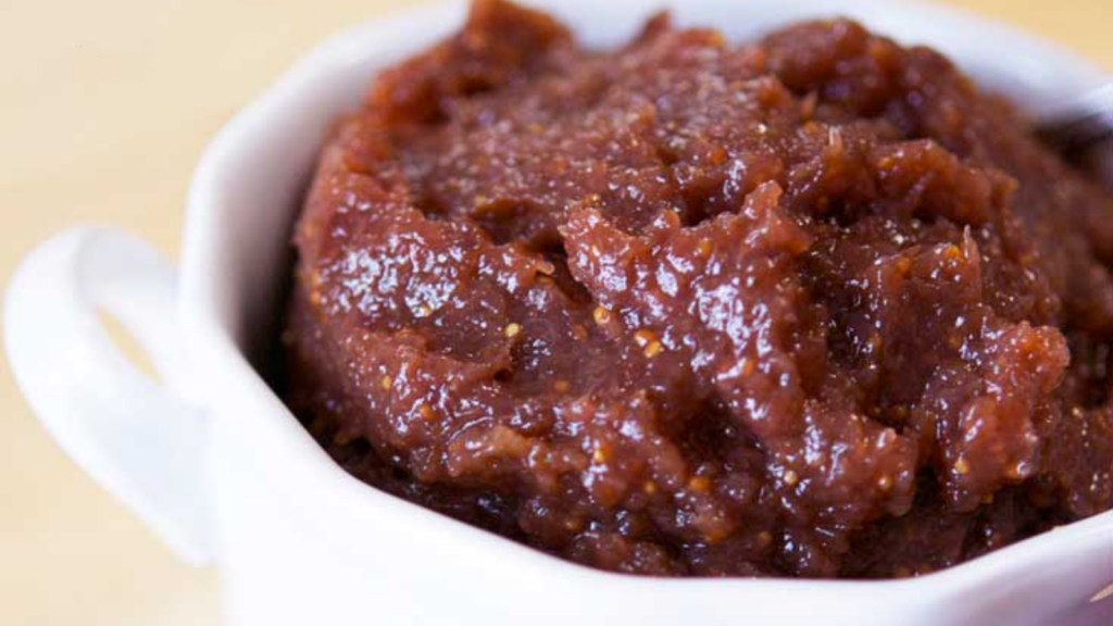 A closeup of a small white crock filled with fig butter.