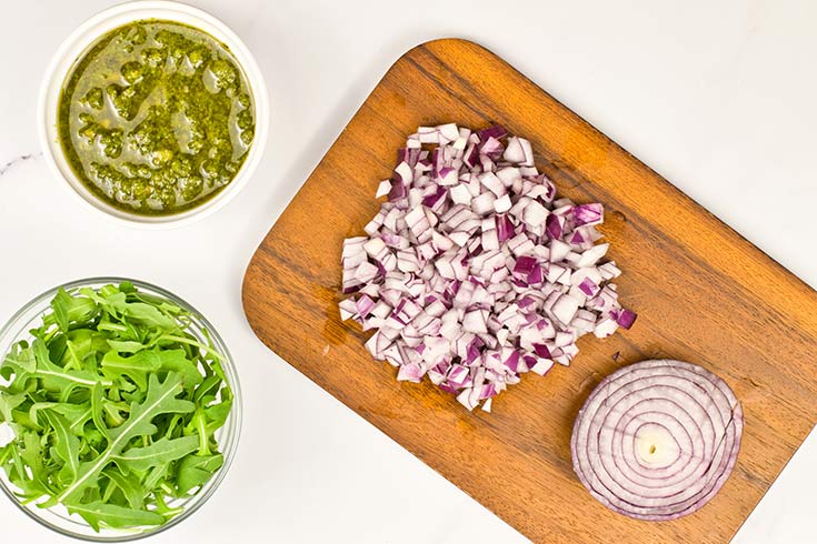 Chopped red onion laying on a cutting board.