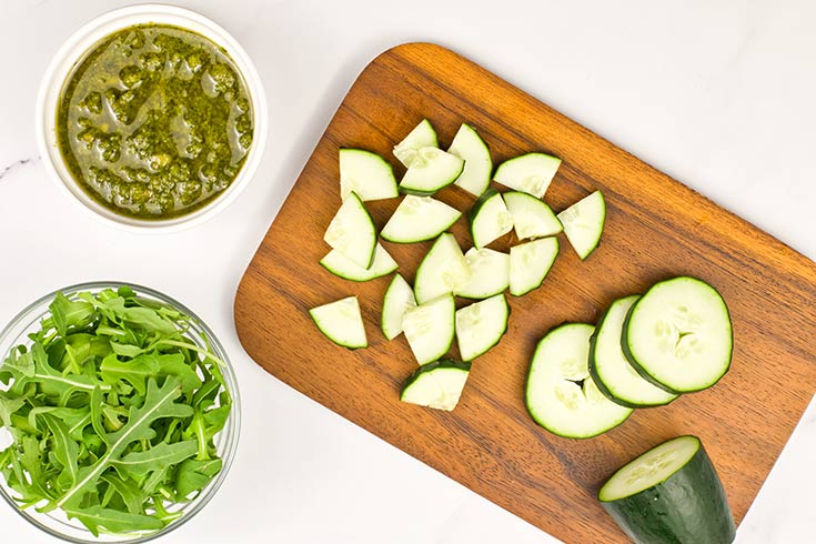 Chopped cucumber laying on a cutting board.