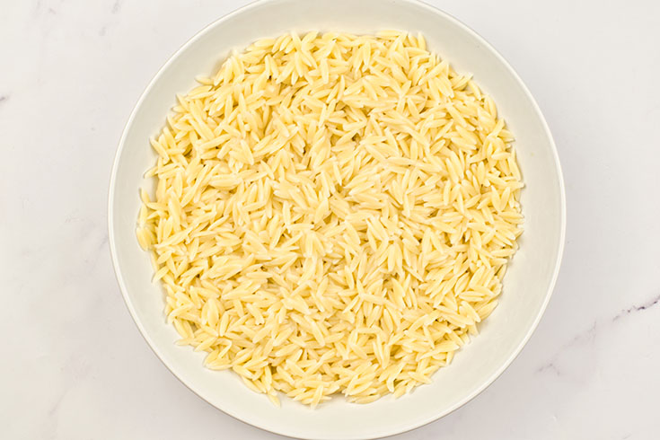 Cooked orzo in a white serving bowl.