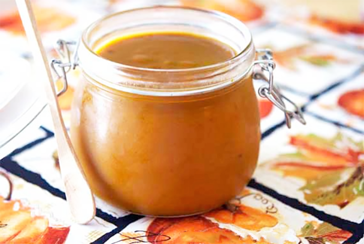 An open canning jar filled with pumpkin butter.