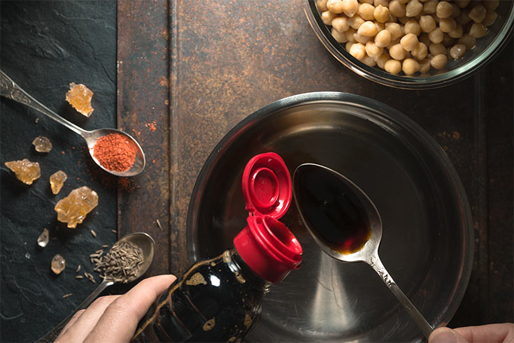 Soy sauce being poured into a pot.