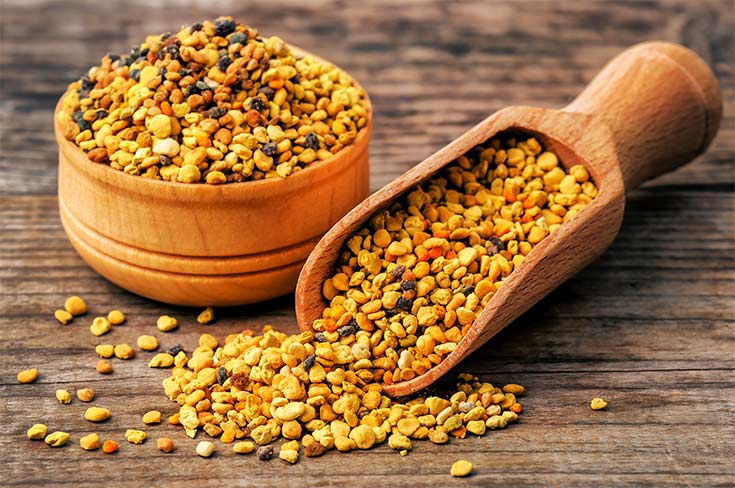 Healthy bee pollen grains on wooden background