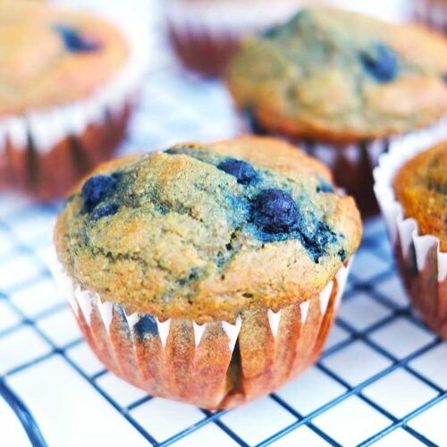 Blueberry corn muffins cooling on a cooling rack.
