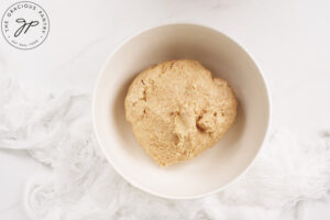 Homemade Cinnamon Roll dough mixed in a white mixing bowl.