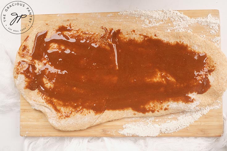 Rolled out dough with honey glaze spread over the top.