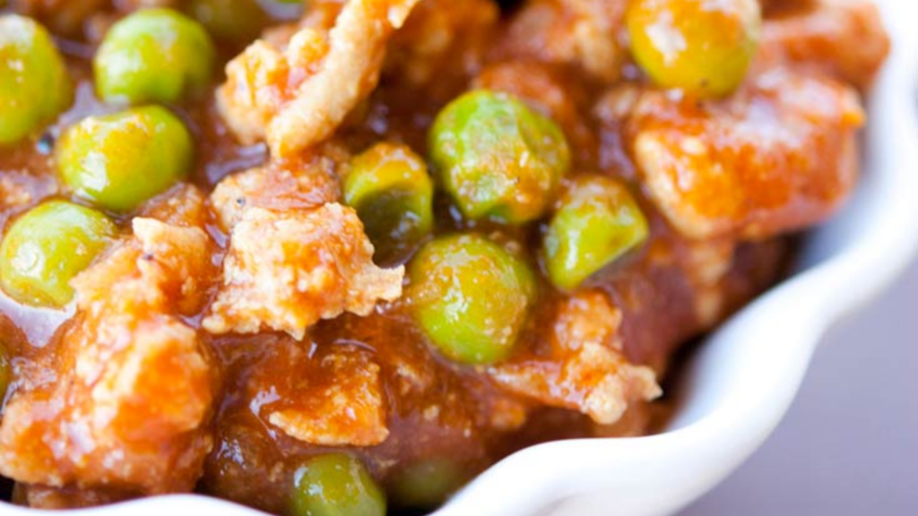 A closeup of a white bowl filled with curried turkey chili.