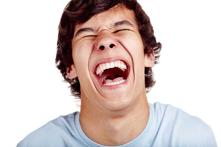A boy laughing loudly.