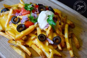 Nacho fries on a wood cutting board.