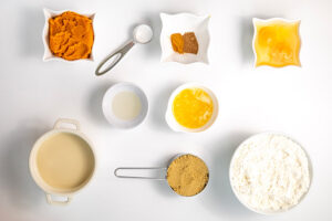Pumpkin Waffles Recipe ingredients lined up in single, white bowls on a white surface.