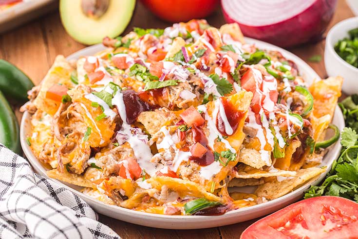 A white platter filled with pulled pork nachos.