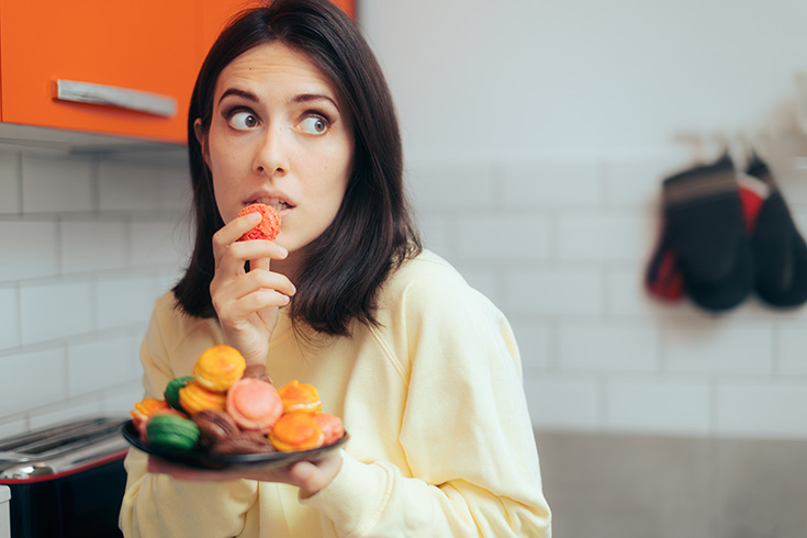 A woman sneaks a plate of cookies.