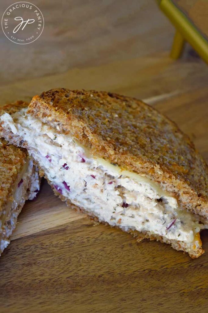 A closeup of a half of an air fryer tuna melt sandwich on a cutting board.