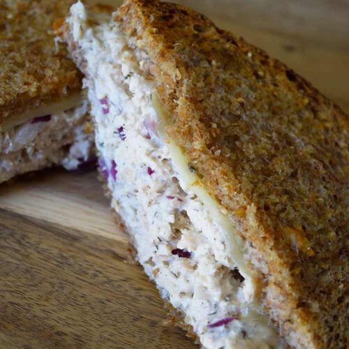 A long view of a half of a tuna melt laying on a cutting board.