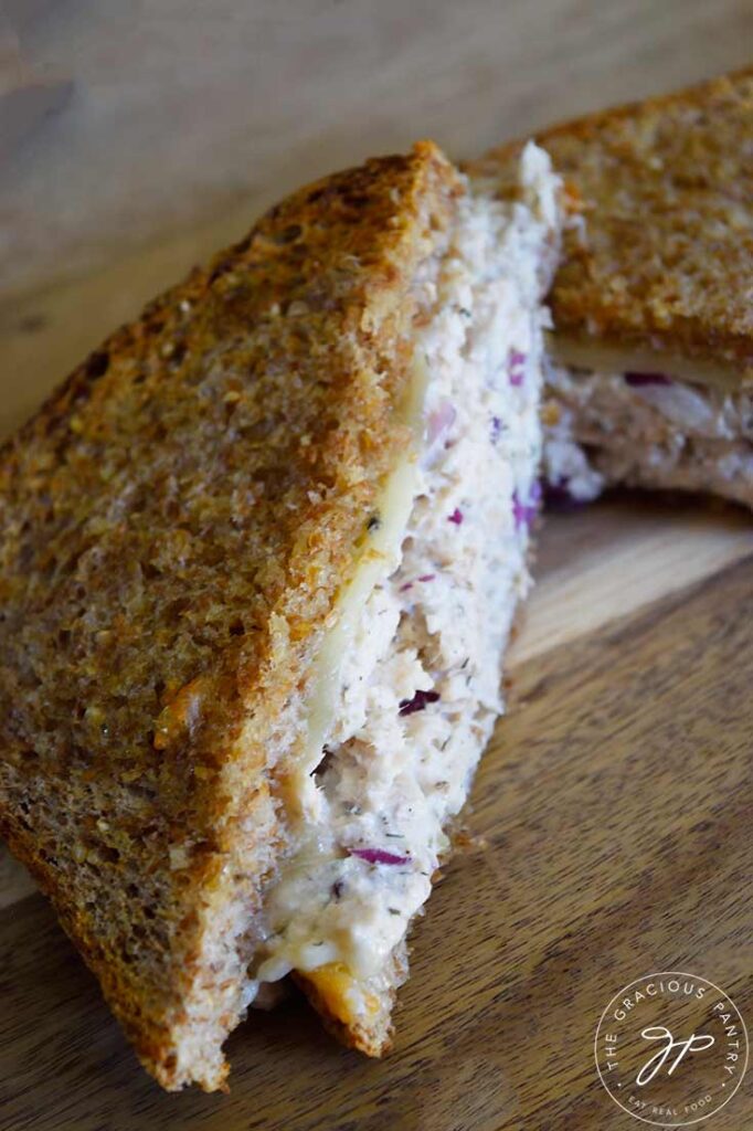 A side view of a half of a tuna melt on a cutting board.