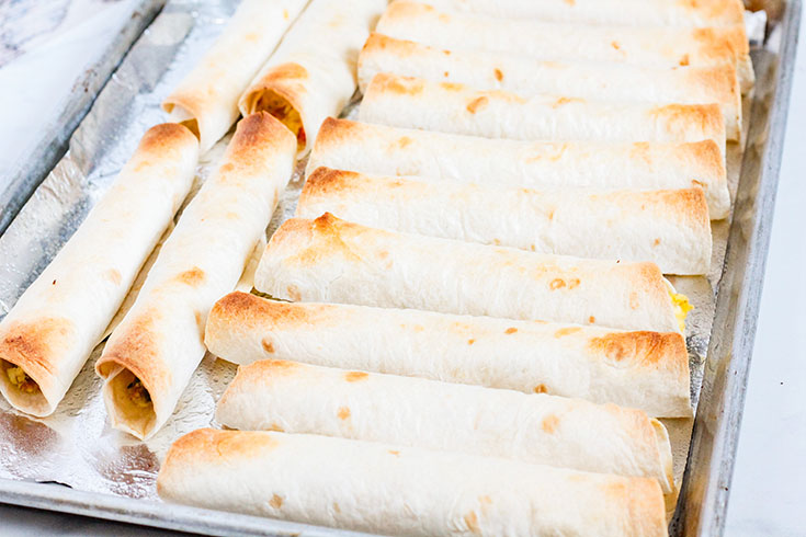 Baked Healthy Breakfast Taquitos cooling on a baking pan after baking.