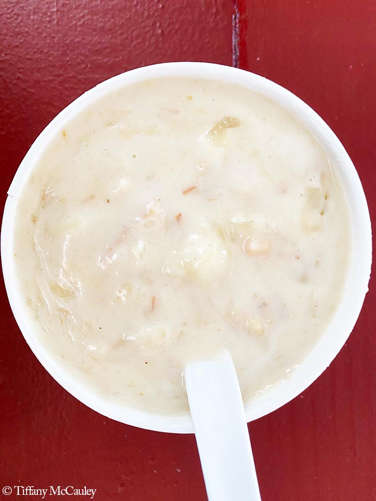 An overhead view of a white cup filled with white chowder.