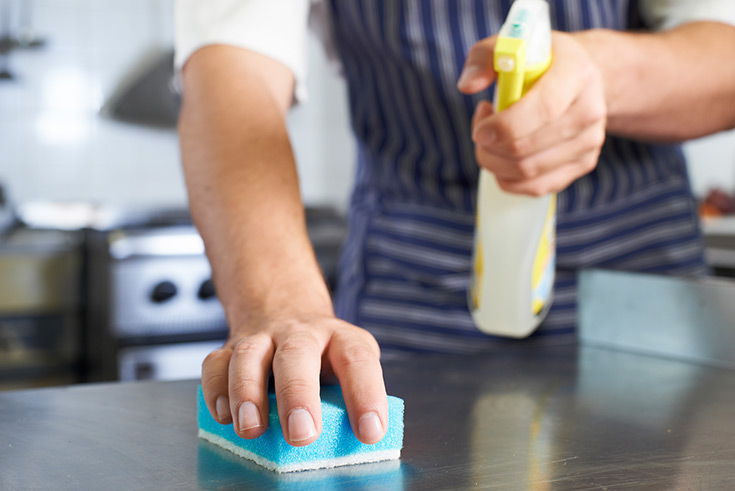 A man cleaning a countertop.