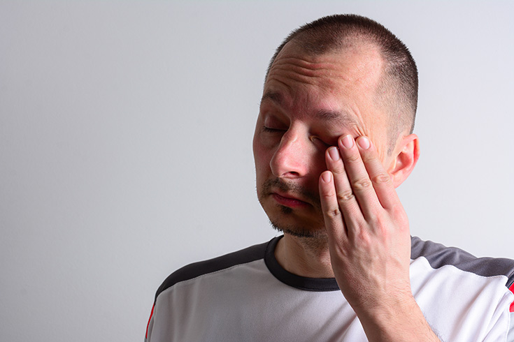 A man rubbing his face.