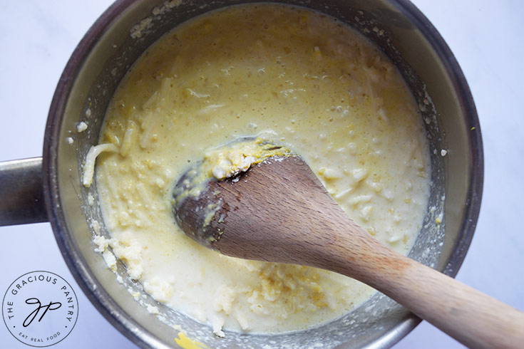 Cheese sauce stirred together in a pot.