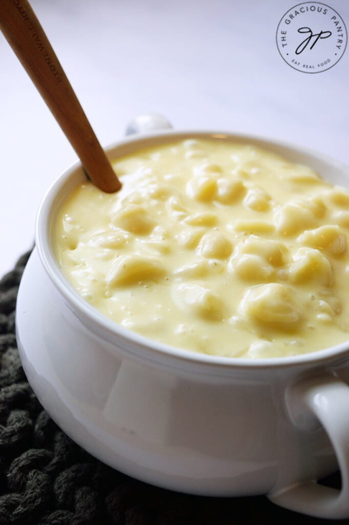 A side view of a white crock filled with Homemade Mac and Cheese.