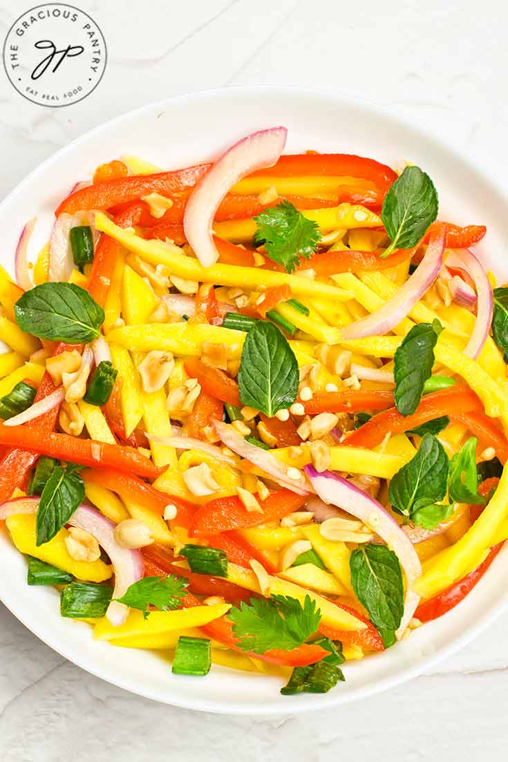 A plateful of mango salad on a white background.