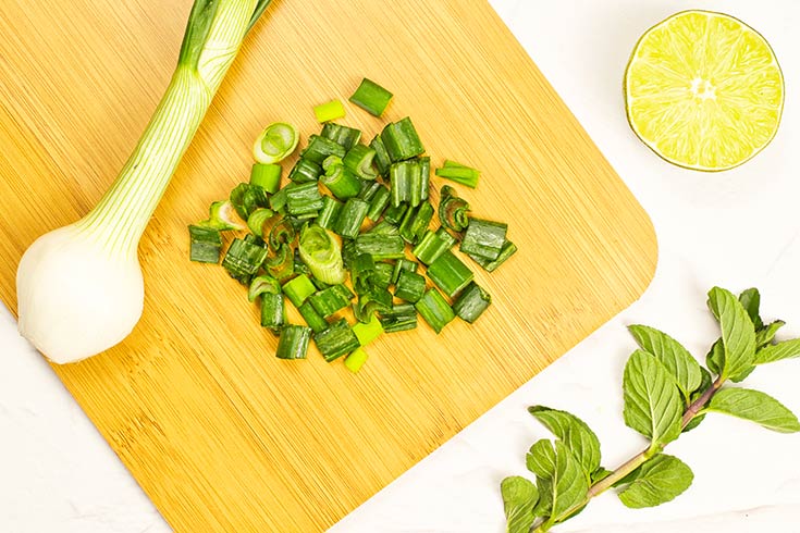 Chopped green onions on a cutting board.