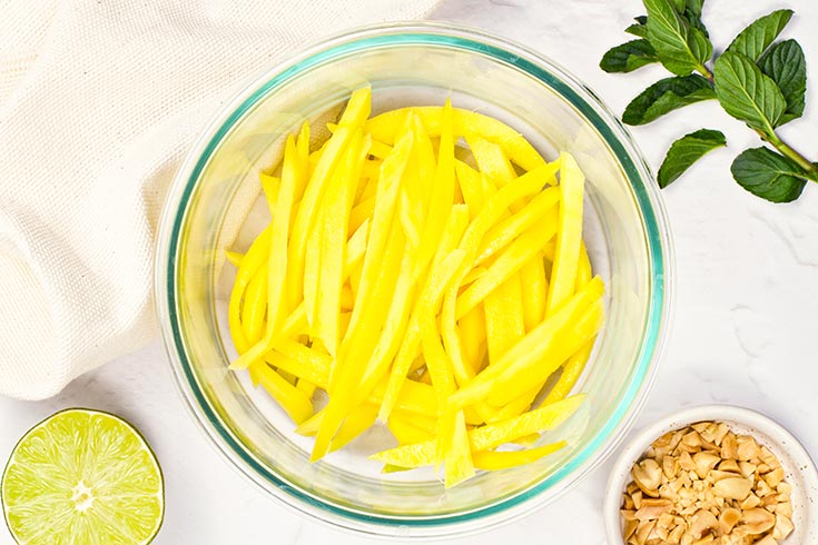 Sliced mango in a mixing bowl.