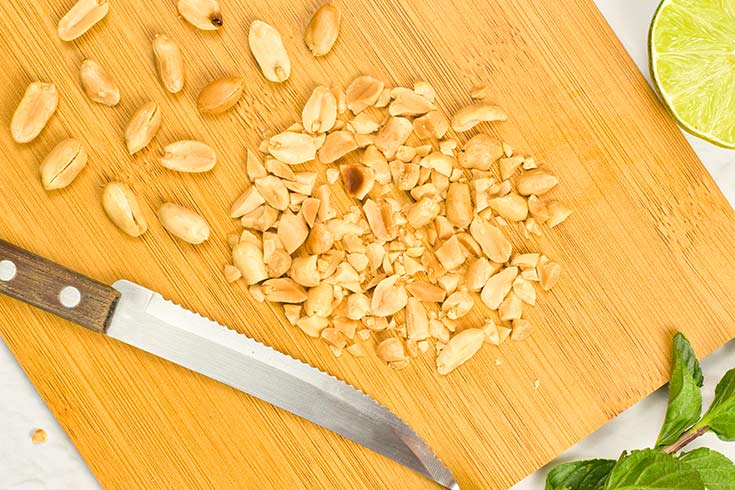 Chopped peanuts on a cutting board.