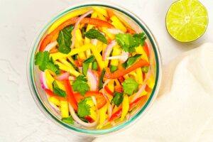 Mango salad garnished with fresh cilantro in a mixing bowl.