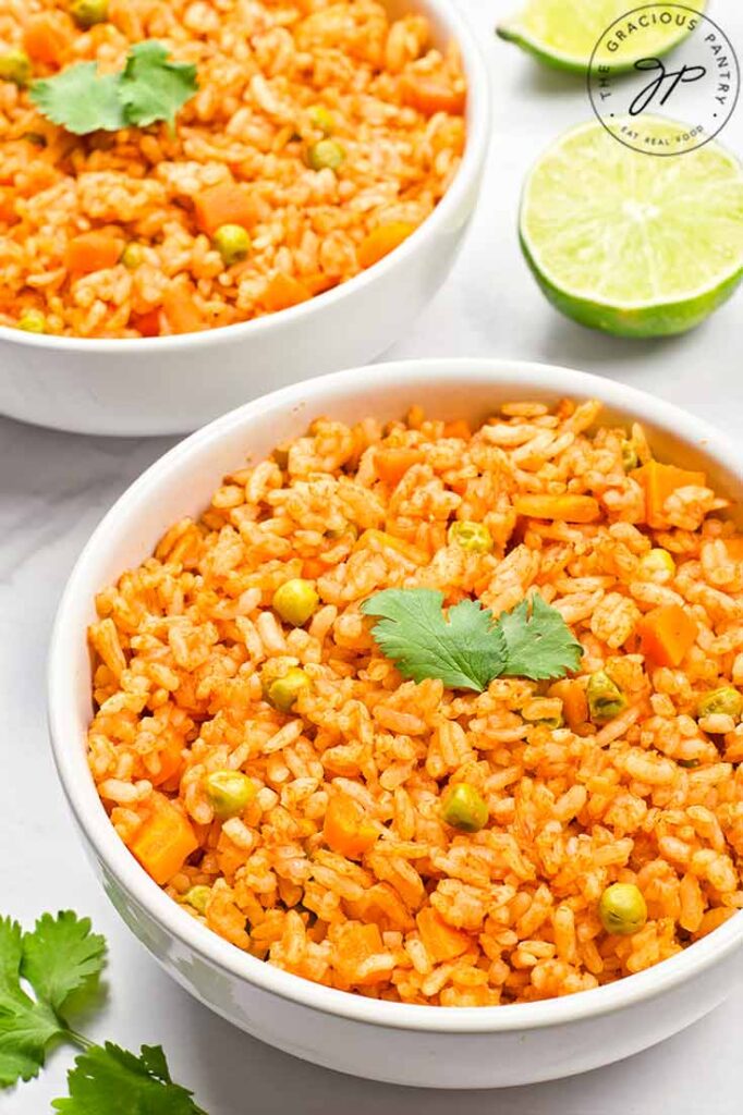 A side view of two white bowls filled with Mexican rice.