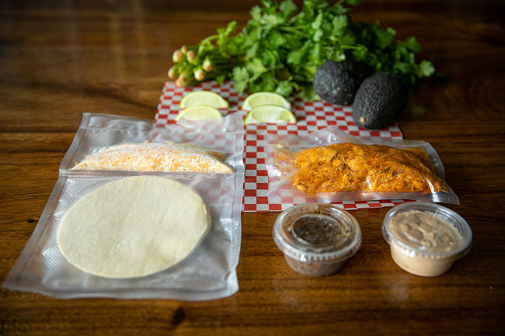 Components of a lunch with dressing and dip wrapped individually and laid on a table.