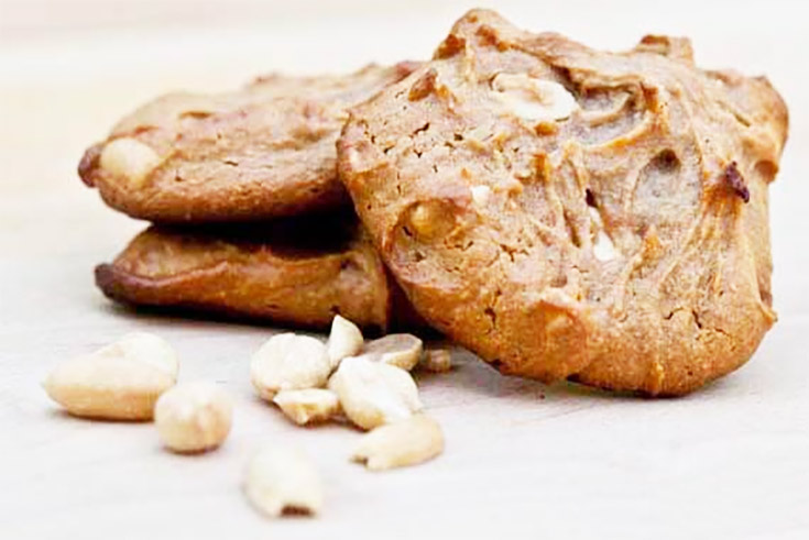 Three Peanut Butter Cookies laying on a wood cutting board.