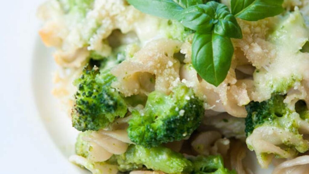 A closeup of a white plate holding a serving of Pesto Broccoli Casserole.