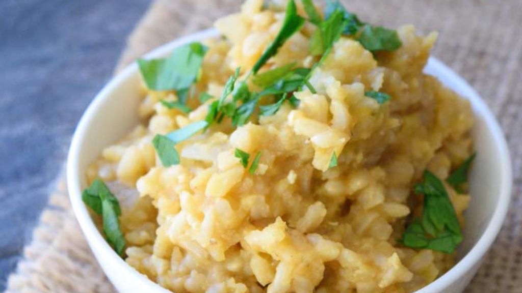 A white bowl filled with red lentil lemon rice.