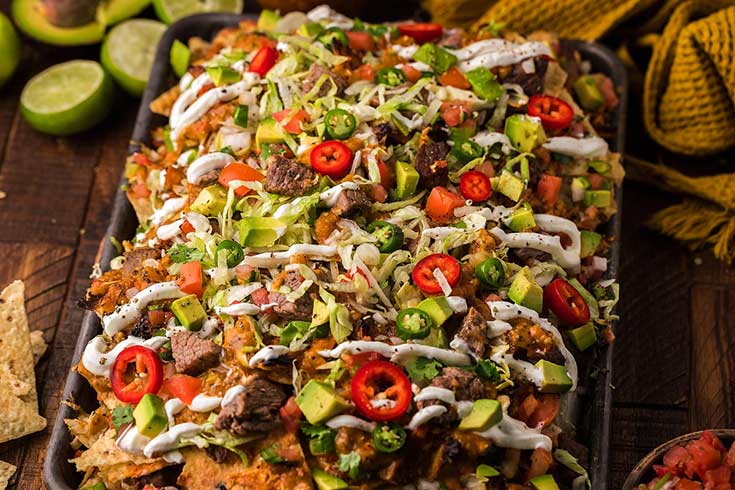 A sheet pan filled with seared steak nachos.