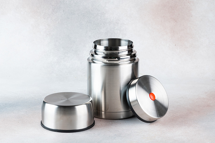 An open thermos sitting on a white background.