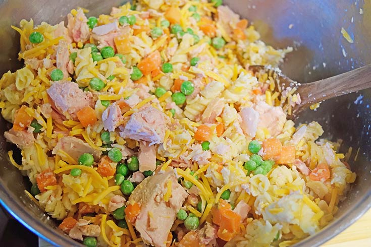 Mixing casserole filling in a large mixing bowl.