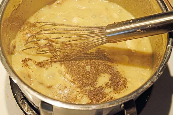 Adding ground pepper to white sauce for Tuna Noodle Casserole.