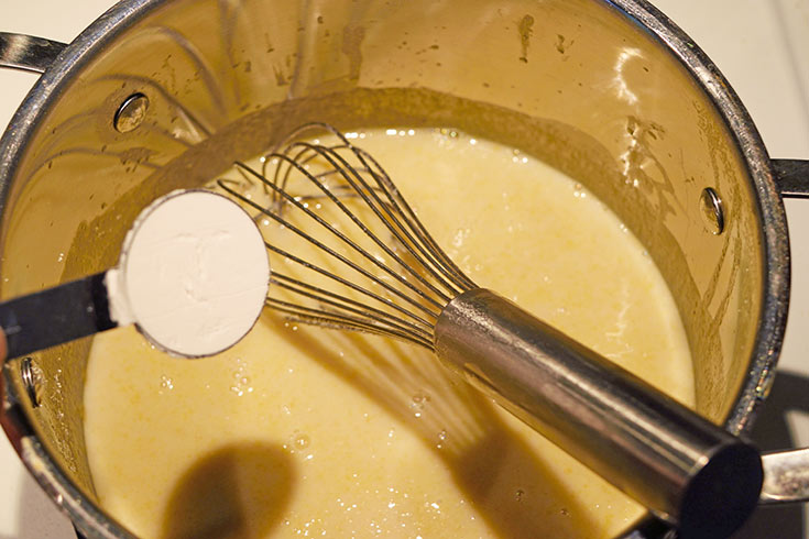 Adding arrowroot powder to melted butter in a pot.