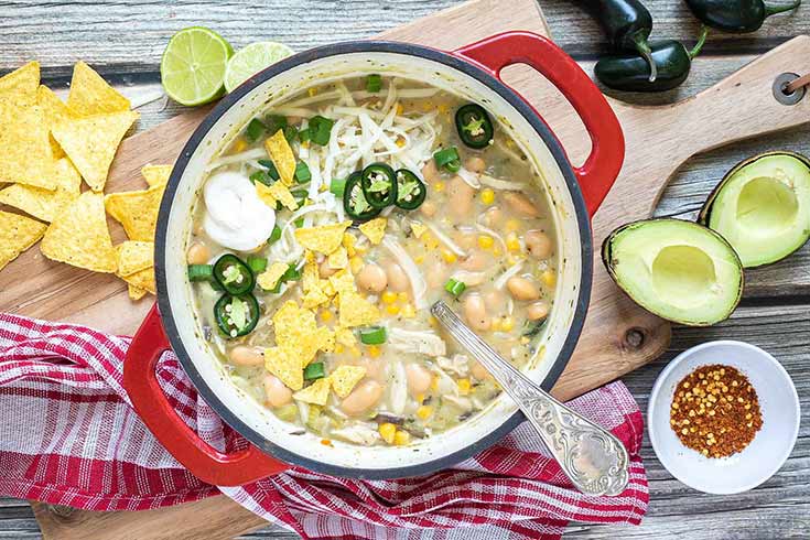 An overhead view of a red crock filled with vegan white chili.