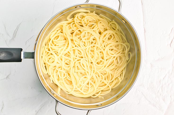 Spaghetti pasta in a strainer.