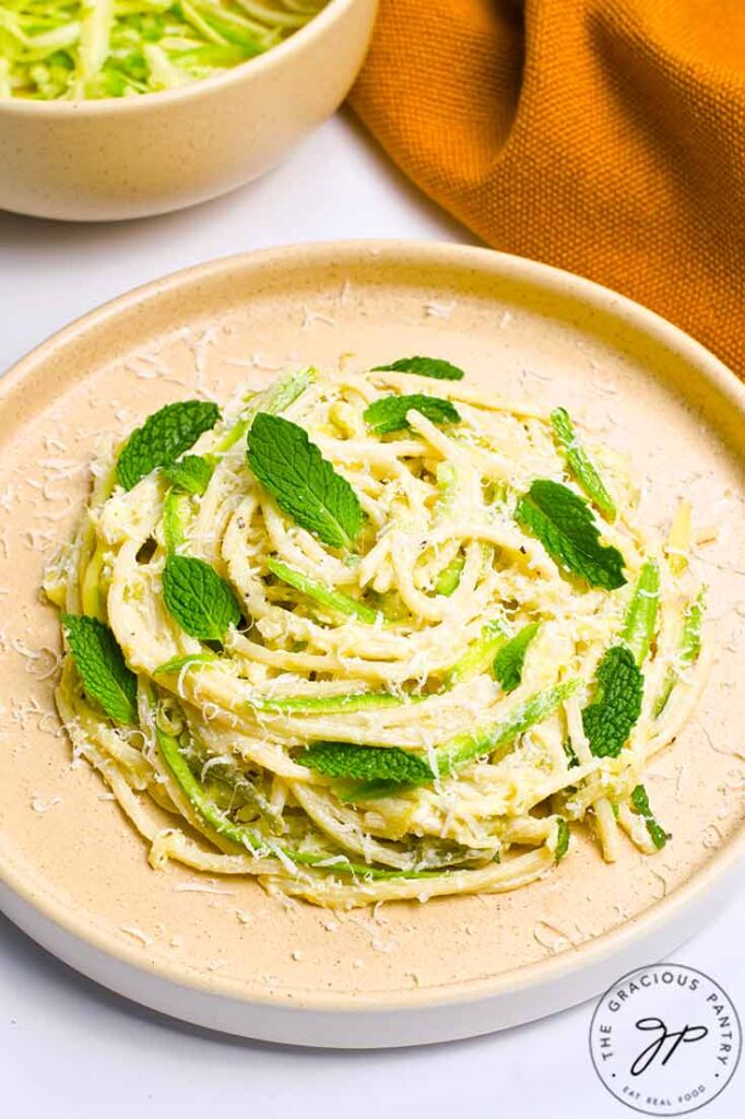 A side view of a nest of zucchini pasta on a plate.